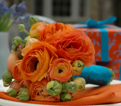 Bright orange wedding bouquet with blue ribbons.PNG